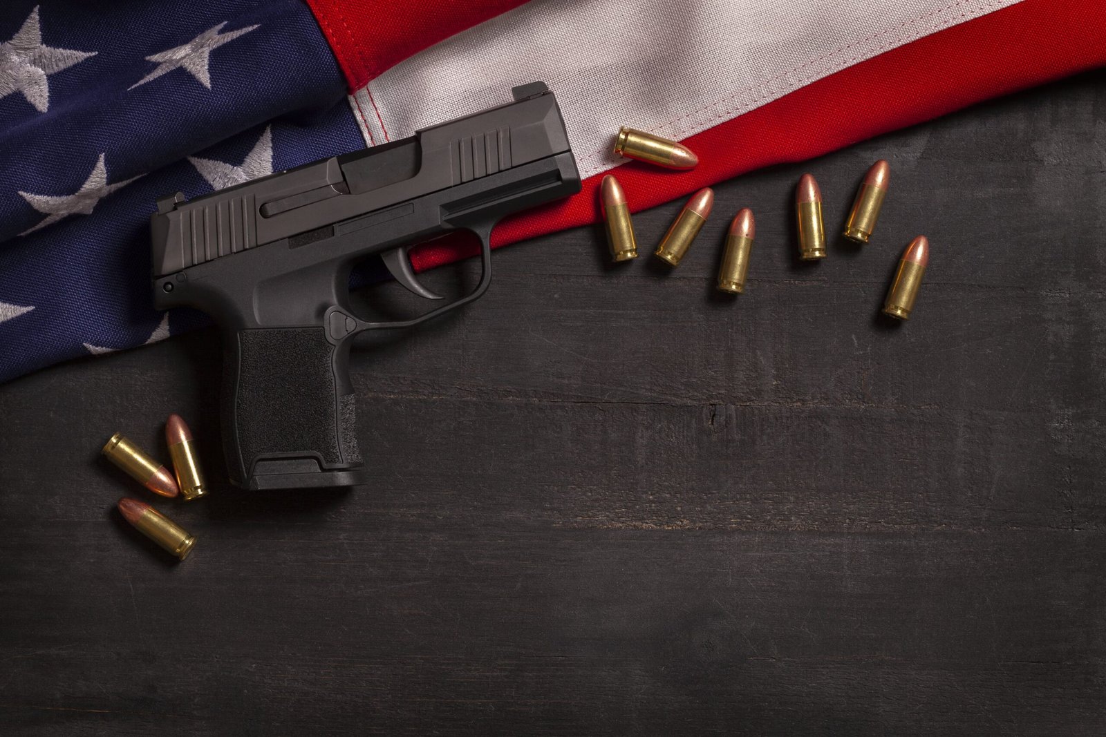 black-pistol-and-bullets-with-an-american-flag-on-2025-01-07-12-36-11-utc-min