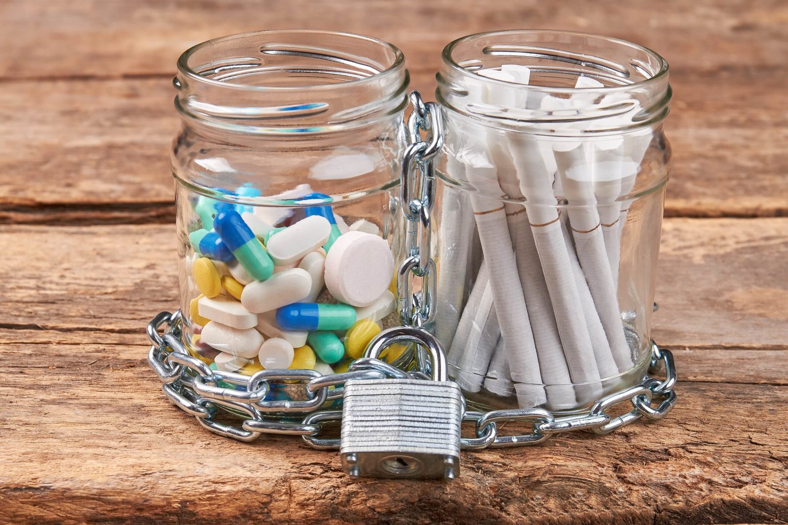 cigarettes-pills-chain-wooden-background-2024-09-22-07-31-14-utc-min