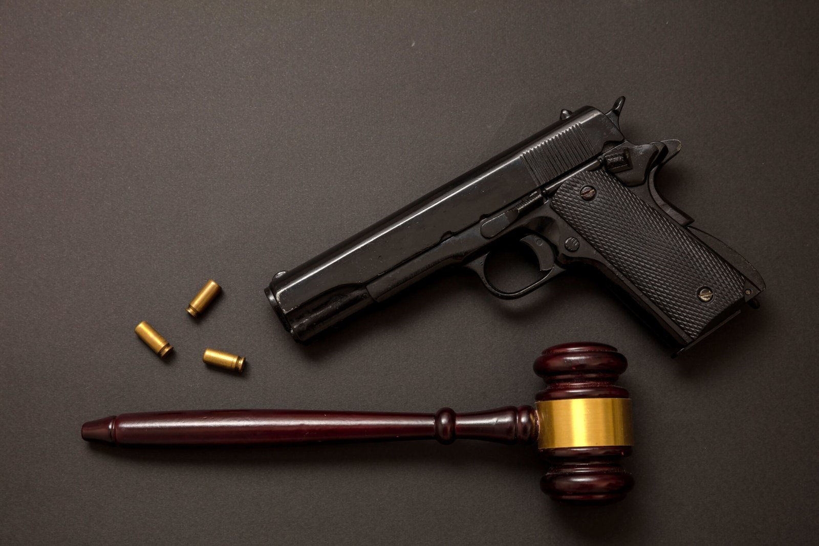 judge-gavel-and-a-9mm-pistol-on-black-background-2024-12-07-16-25-05-utc-min